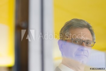 Portrait confident mature businessman at window