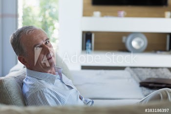 Portrait confident senior man on living room sofa