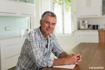 Portrait confident senior man with notebook at kitchen table