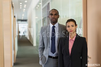 Portrait confident serious business people in office corridor
