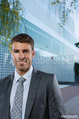 Portrait confident smiling corporate businessman outside office building