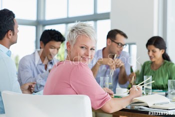 Portrait confident woman eating sushi lunch with colleagues