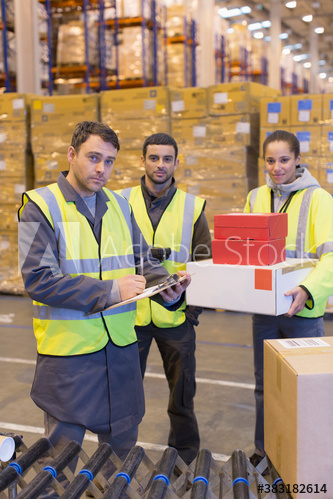Portrait confident workers with packages in distribution warehouse