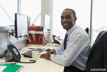 Portrait confident young businessman working at computer in office