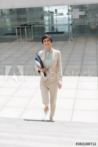 Portrait confident young businesswoman climbing steps
