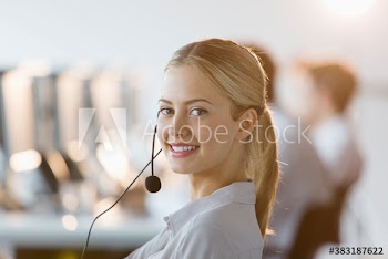 Portrait confident young businesswoman with headset in call center