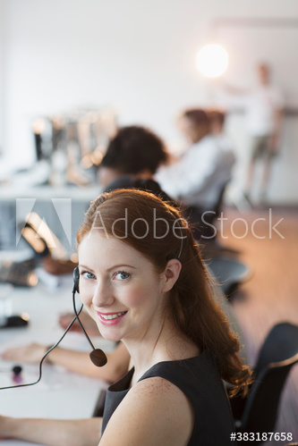 Portrait confident young businesswoman working in call center