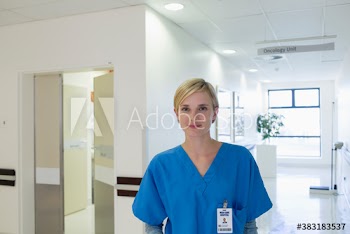 Portrait confident young female nurse in hospital corridor