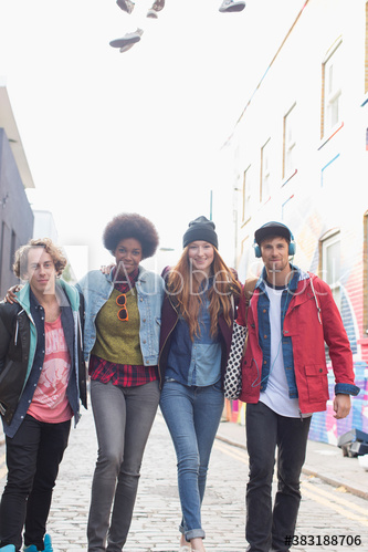 Portrait confident young friends walking on city street
