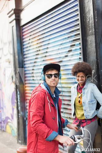 Portrait confident young man and woman near graffiti wall