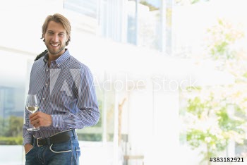 Portrait confident young man drinking white wine