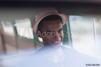 Portrait confident young man in hat riding in van