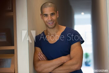 Portrait confident young man with arms crossed in hallway