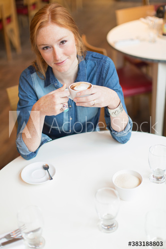 Portrait confident young woman drinking cappuccino in cafe