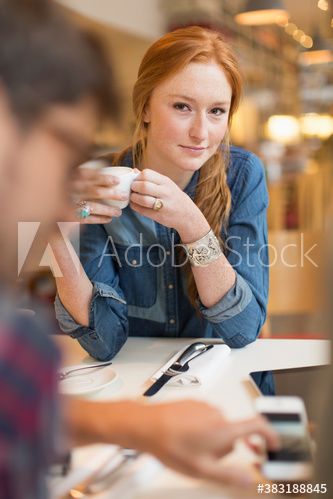 Portrait confident young woman drinking coffee in cafe