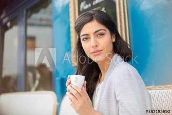 Portrait confident young woman drinking espresso at sidewalk cafe