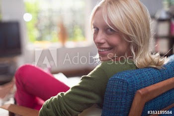 Portrait confident young woman relaxing in armchair