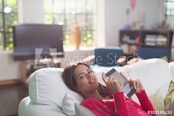 Portrait confident young woman using digital tablet on sofa