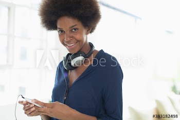 Portrait confident young woman with afro listening to music
