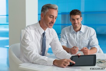 Portrait corporate businessman using digital tablet in meeting
