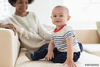 Portrait cute baby boy and mother on sofa