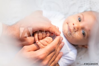 Portrait cute baby boy holding hands with father