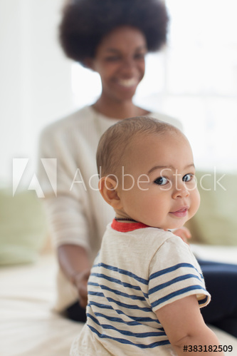 Portrait cute baby boy on sofa with mother
