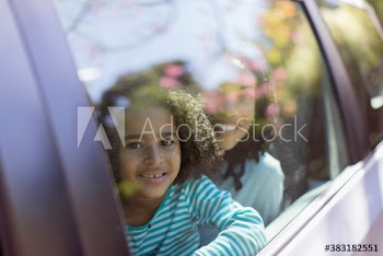 Portrait cute mother and daughter in car window