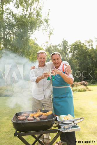 Portrait father and adult son barbecuing and enjoying cocktails