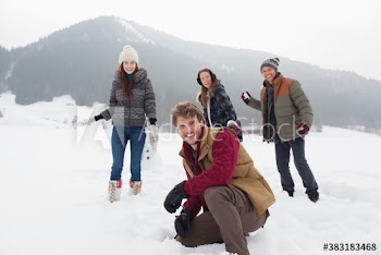 Portrait friends enjoying snowball fight in snowy field