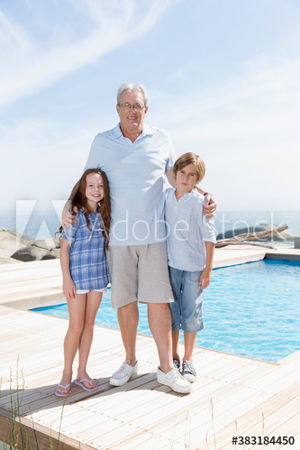 Portrait grandfather and grandkids at sunny poolside