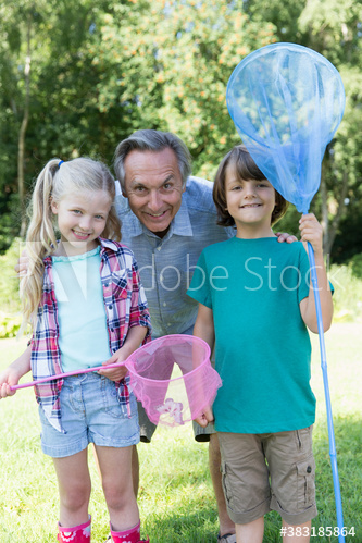 Portrait grandfather and grandkids catching butterflies with nets