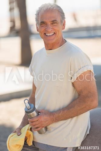 Portrait happy active senior man with water bottle exercising