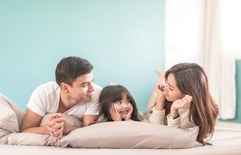 Portrait Happy Asian Family in bedroom looking at each other.