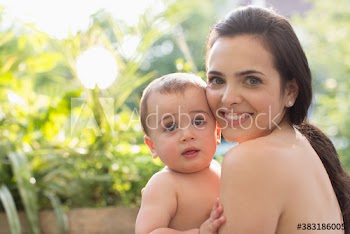 Portrait happy bare chested mother and baby son on patio