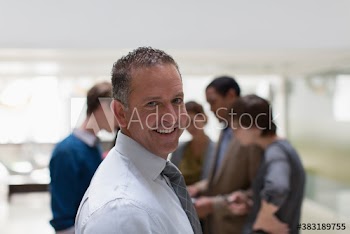 Portrait happy businessman with colleagues in office