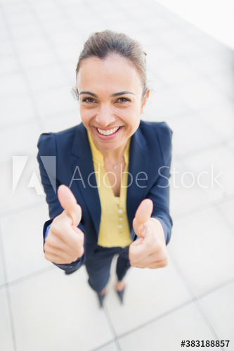 Portrait happy businesswoman gesturing thumbs up