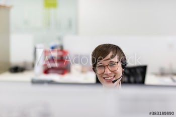 Portrait happy businesswoman with headset working in office