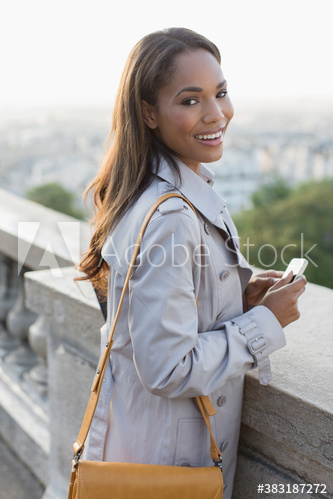 Portrait happy businesswoman with smart phone outdoors