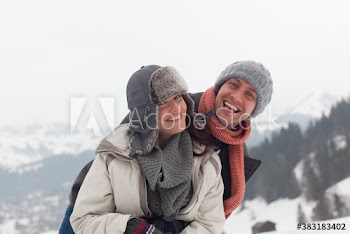 Portrait happy couple hugging in snowy field