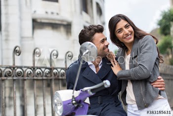 Portrait happy couple hugging on scooter, Paris, France