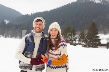 Portrait happy couple in knit hats and sweaters in snow
