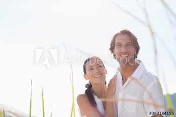 Portrait happy couple in sunny grass