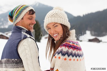 Portrait happy couple wearing knit hats in snow