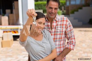 Portrait happy couple with new house keys in driveway
