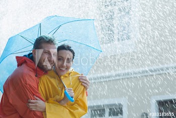 Portrait happy couple with umbrella in rain