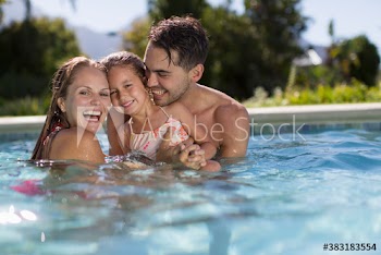 Portrait happy family in sunny swimming pool