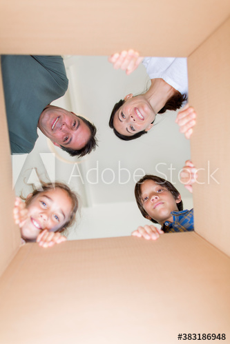 Portrait happy family looking into cardboard moving box