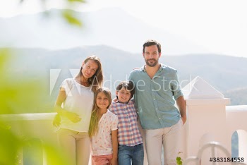 Portrait happy family on sunny balcony