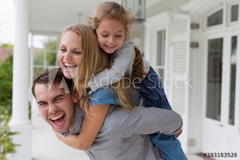 Portrait happy family piggybacking on patio